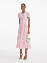 Side view of a woman wearing the Pink Lace Embellished Midi Dress