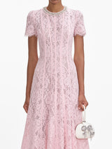 A close up of a woman wearing the Pink Lace Embellished Midi Dress