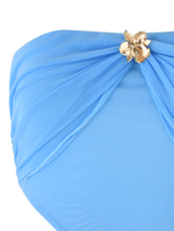 Close-up of the TIGERMIST KYNLEE DRESS in sky blue, featuring sheer mesh fabric, a strapless neckline, and a gold flower-shaped embellishment at the waist.